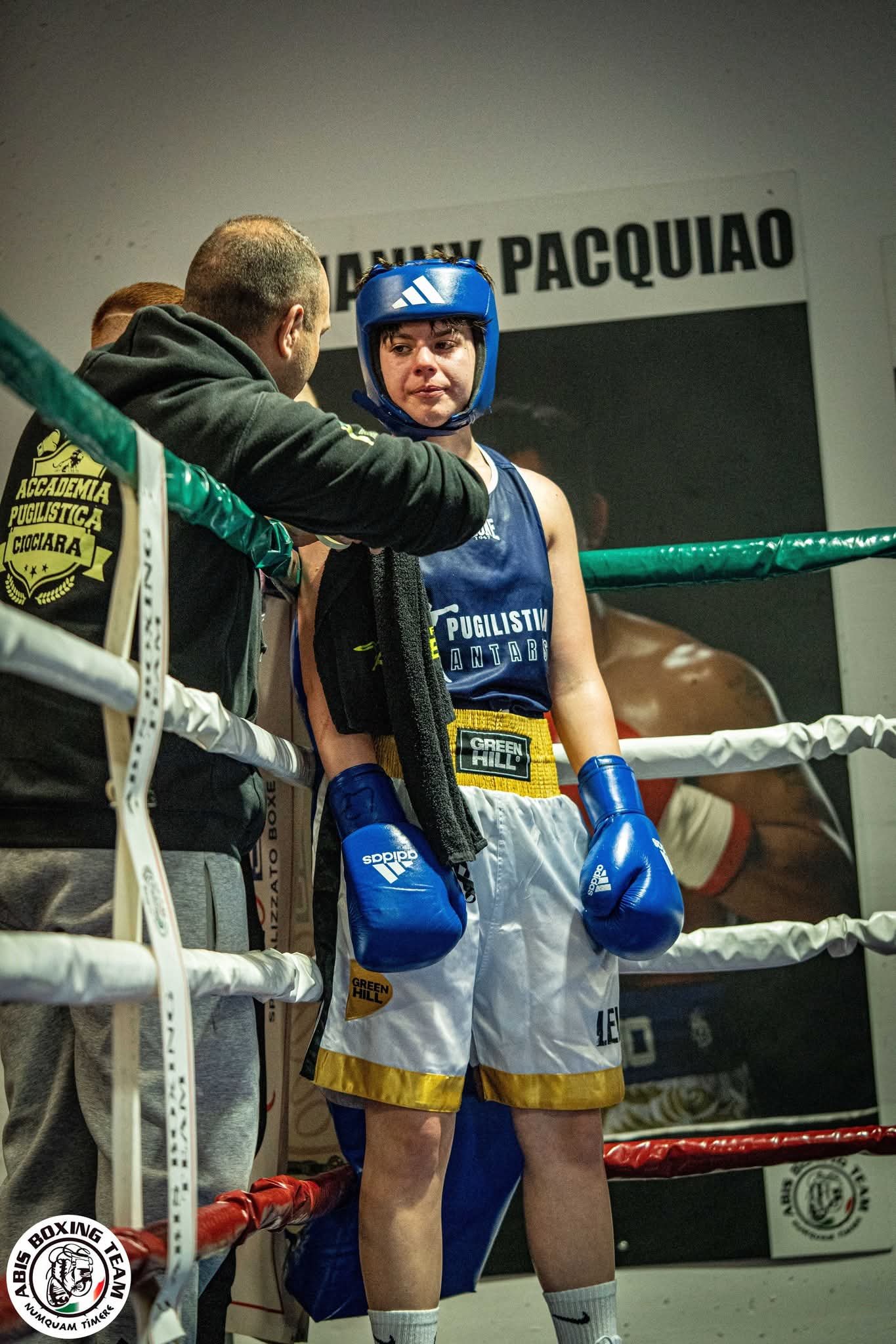 Il maestro sistema i guantoni all'atleta a bordo ring
