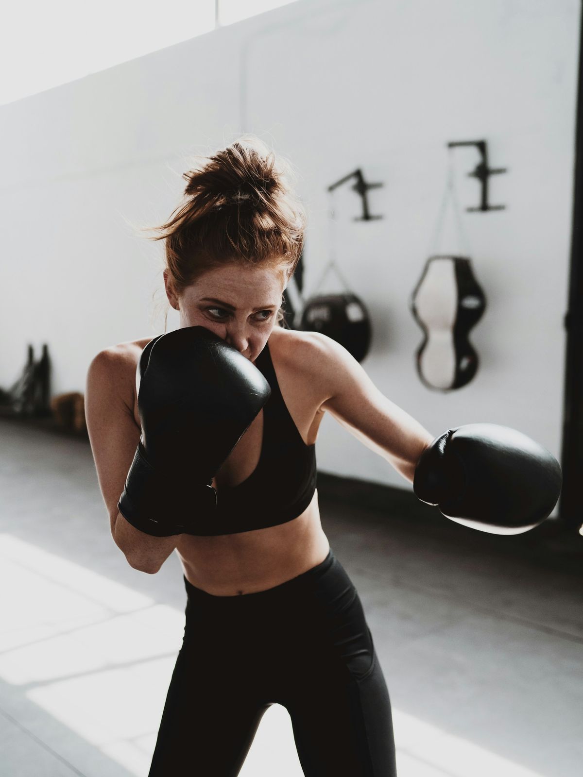 Ragazza in guardia con i guantoni durante un allenamento di boxe